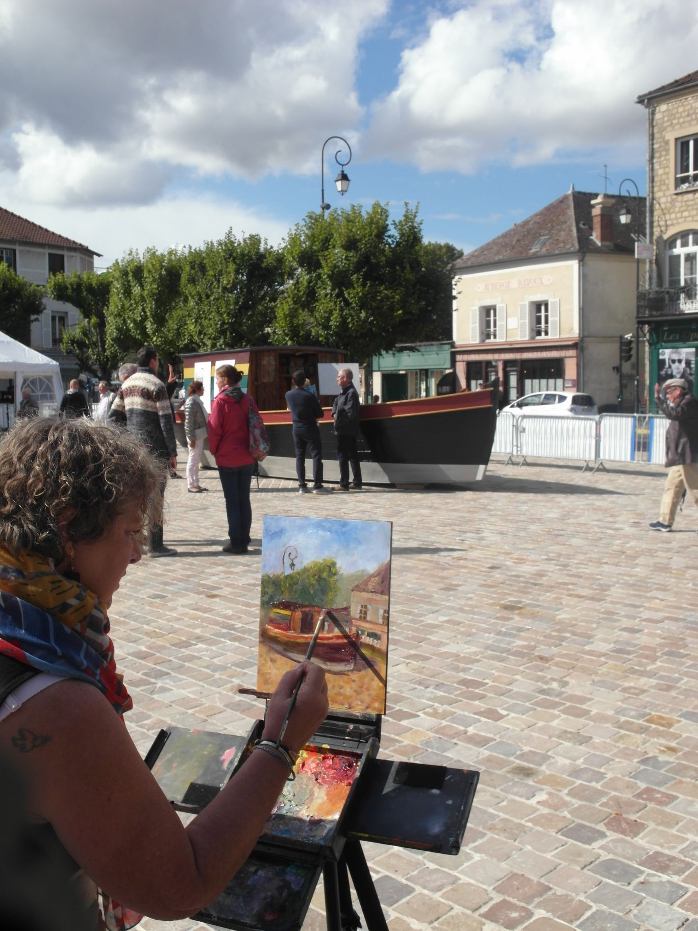 un artiste est en train de peindre le bateau sur l aplace de l'hotel de ville