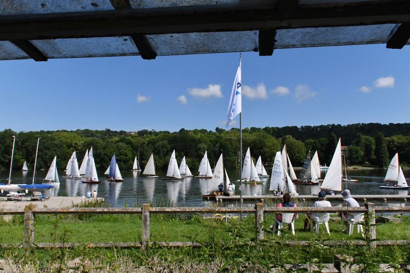 Devant le club de l'YCIF, on voit le plan d'eau sur lequel naviguent plusieurs dizaines de voiliers
