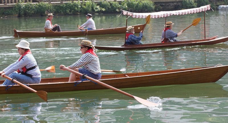 3 bateaux en bois à rames avec 2 ou 3 rameurs 