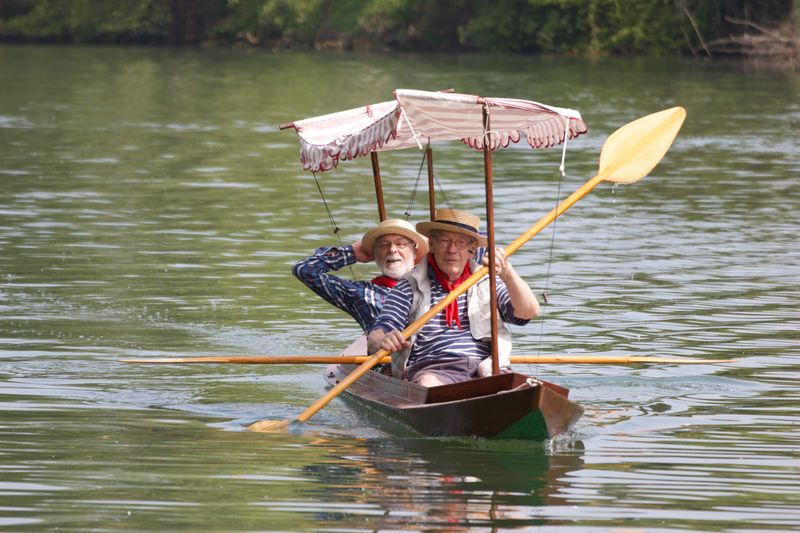 La périssoire Prosper avec son taud rayé arrive avec ses deux pagayeurs