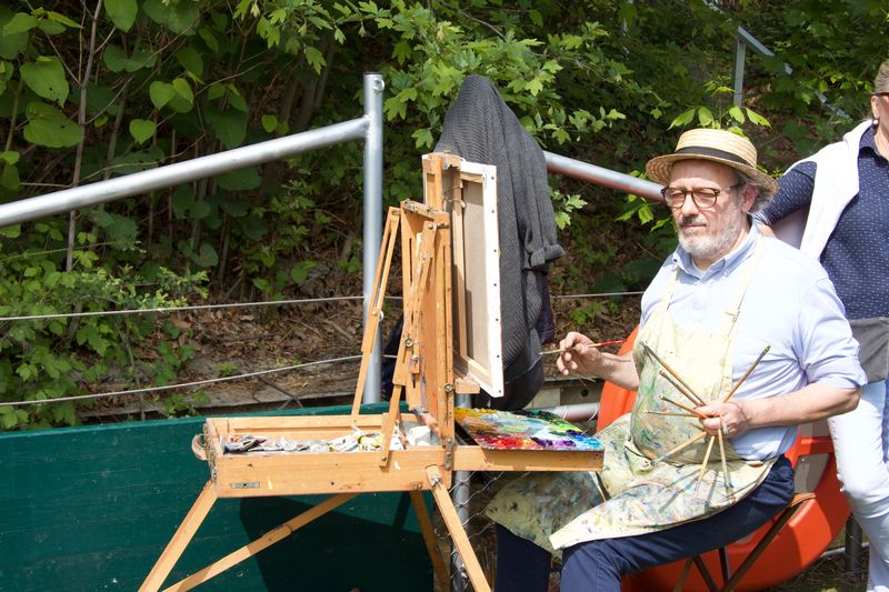 Un peintre avec ses pinceaux et sa toile regarde son motif, en l'occurence les danseurs
